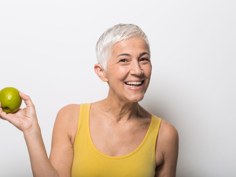 Femme d'âge mûr tenant une pomme